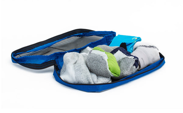 An open Small Tri-Star Packing Cube in Island (blue) 120 Aether filled with socks.